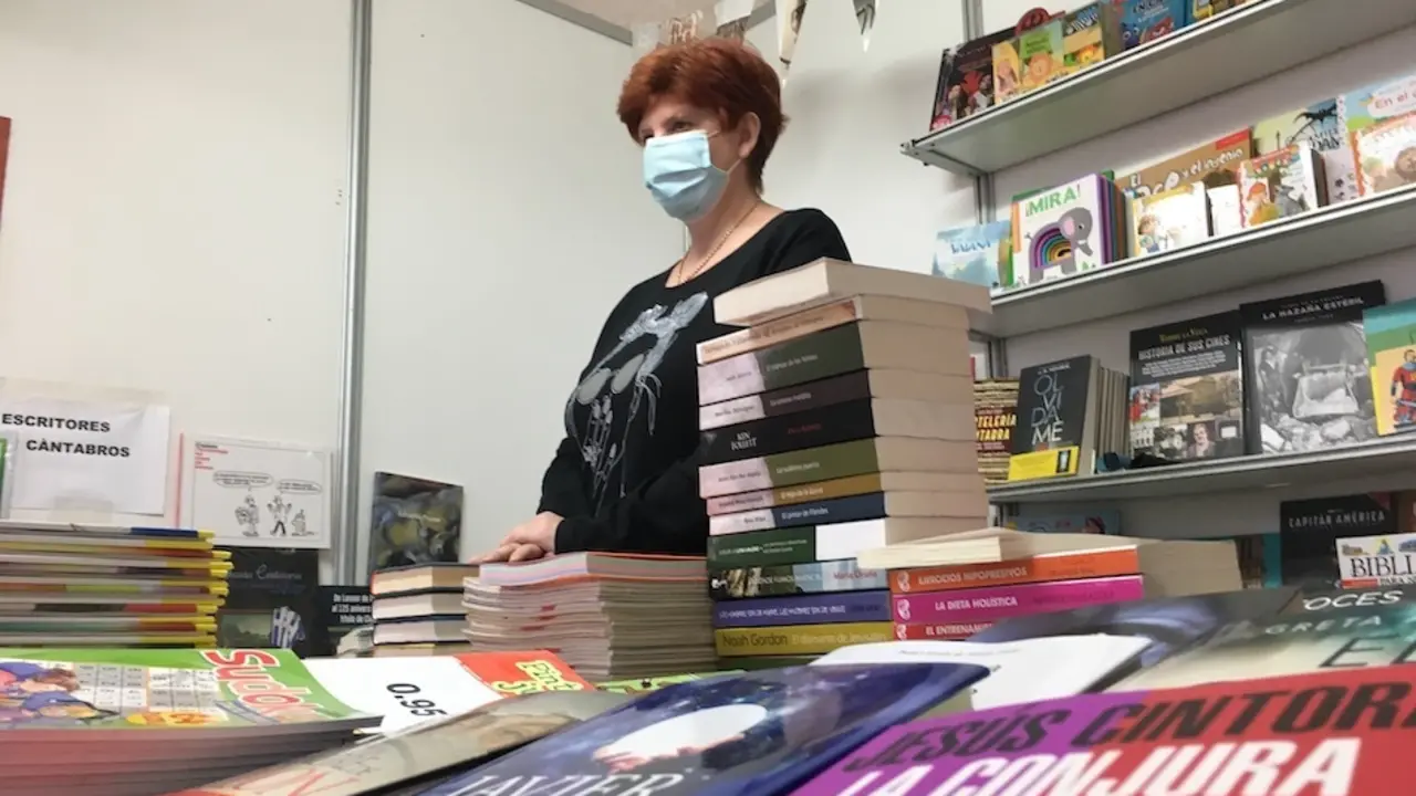 La dependiente espera a los posibles clientes en el stand de la librer&iacute;a La Virgen Grande de Torrelavega. / S.D.