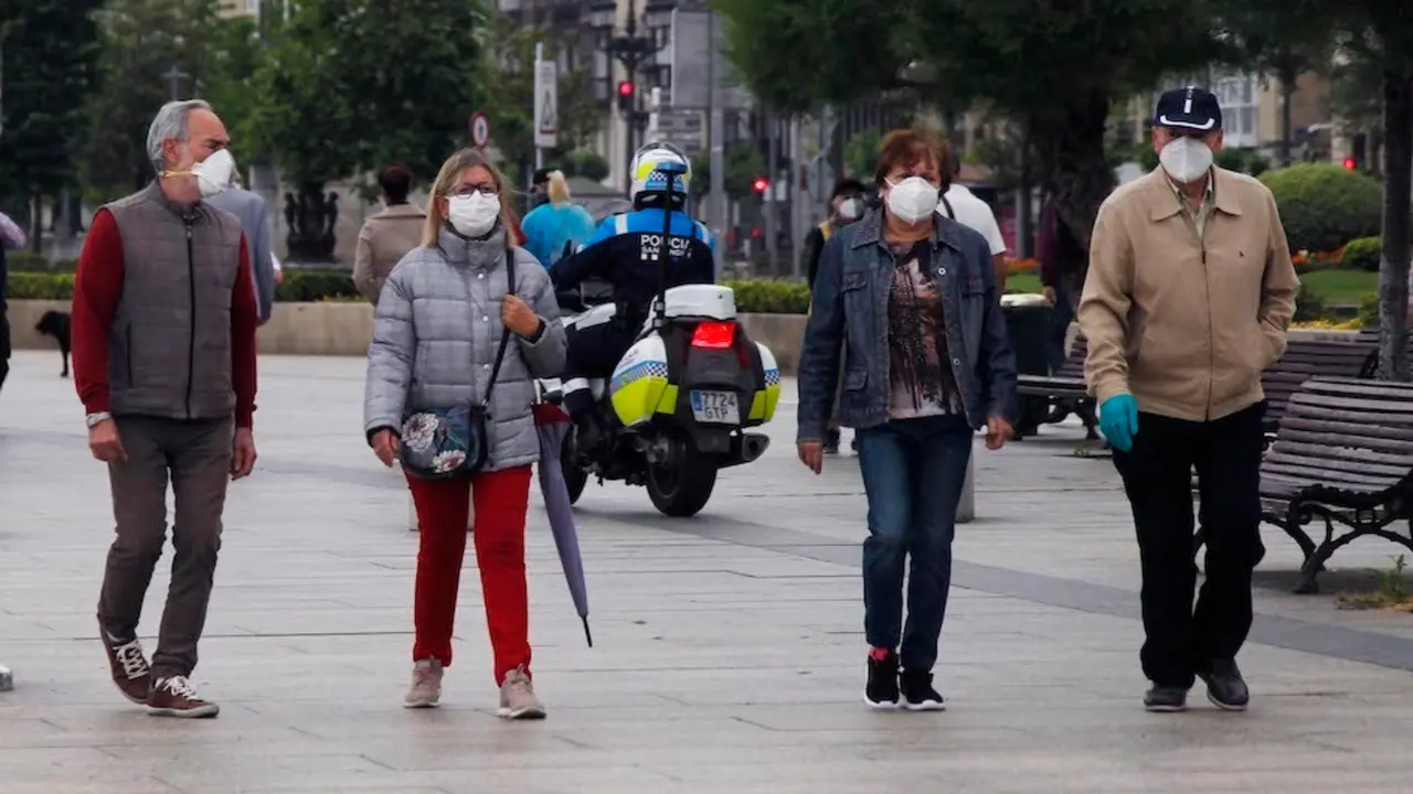 Varias personas con mascarilla caminan por el Paseo Pereda en Santander, donde se ha detectado un brote de coronavirus. / J. Ram&oacute;n