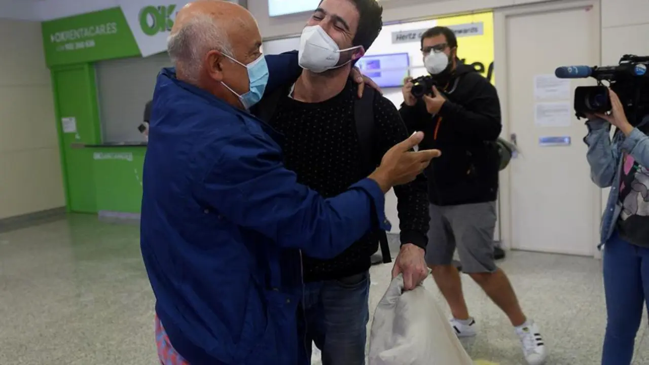 Un padre recibe a su hijo procedente de Viena este jueves en el aeropuerto Seve Ballesteros en Cantabria. FOTO/EFE/Pedro Puente Hoyos