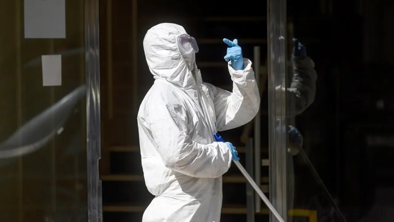 Un hombre desinfecta este martes el portal del edificio de Santander en la calle Nicol&aacute;s Salmer&oacute;n, donde los vecinos llevan m&aacute;s de diez d&iacute;as confinados en sus domicilios tras detectarse un brote de coronavirus en ese inmueble que afecta a 15 de sus 80 residentes y esperan la prueba PCR que les van a realizar hoy para conocer si en las pr&oacute;ximas horas pueden finalizar su cuarentena y salir ya de sus casas. EFE/Pedro Puente Hoyos