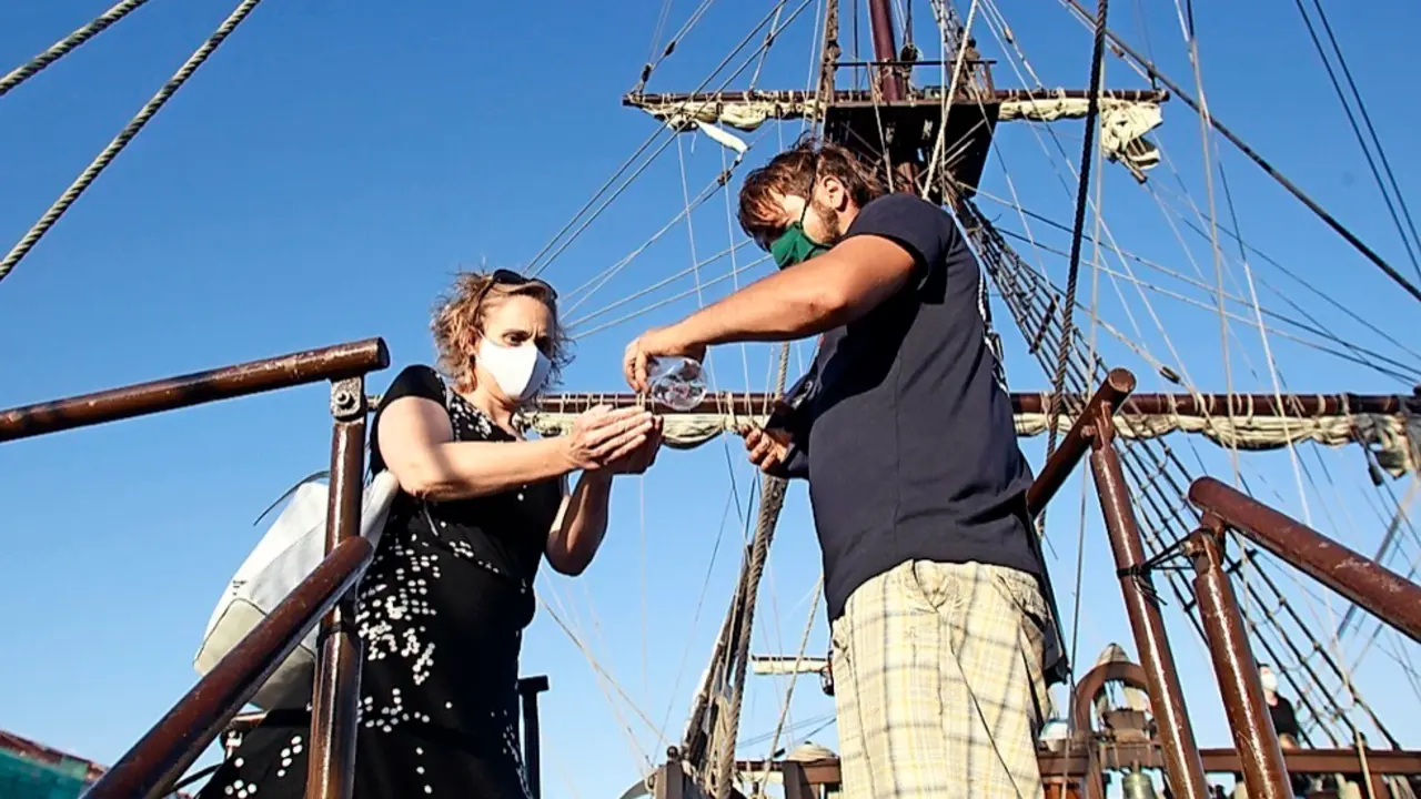 Un visitante se desinfecta en la entrada a la cubierta del 'Gale&oacute;n Andaluc&iacute;a'. / J. Ram&oacute;n Gonz&aacute;lez