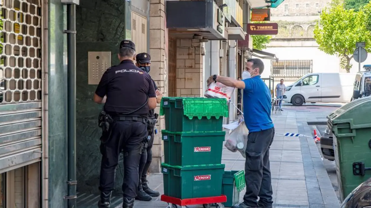Miembros de la Polic&iacute;a Nacional hablan con un repartidor mientras montan guardia frente al edificio en la calle Nicol&aacute;s Salmer&oacute;n de Santander. / EFE/ROM&Aacute;N G. AGUILERA