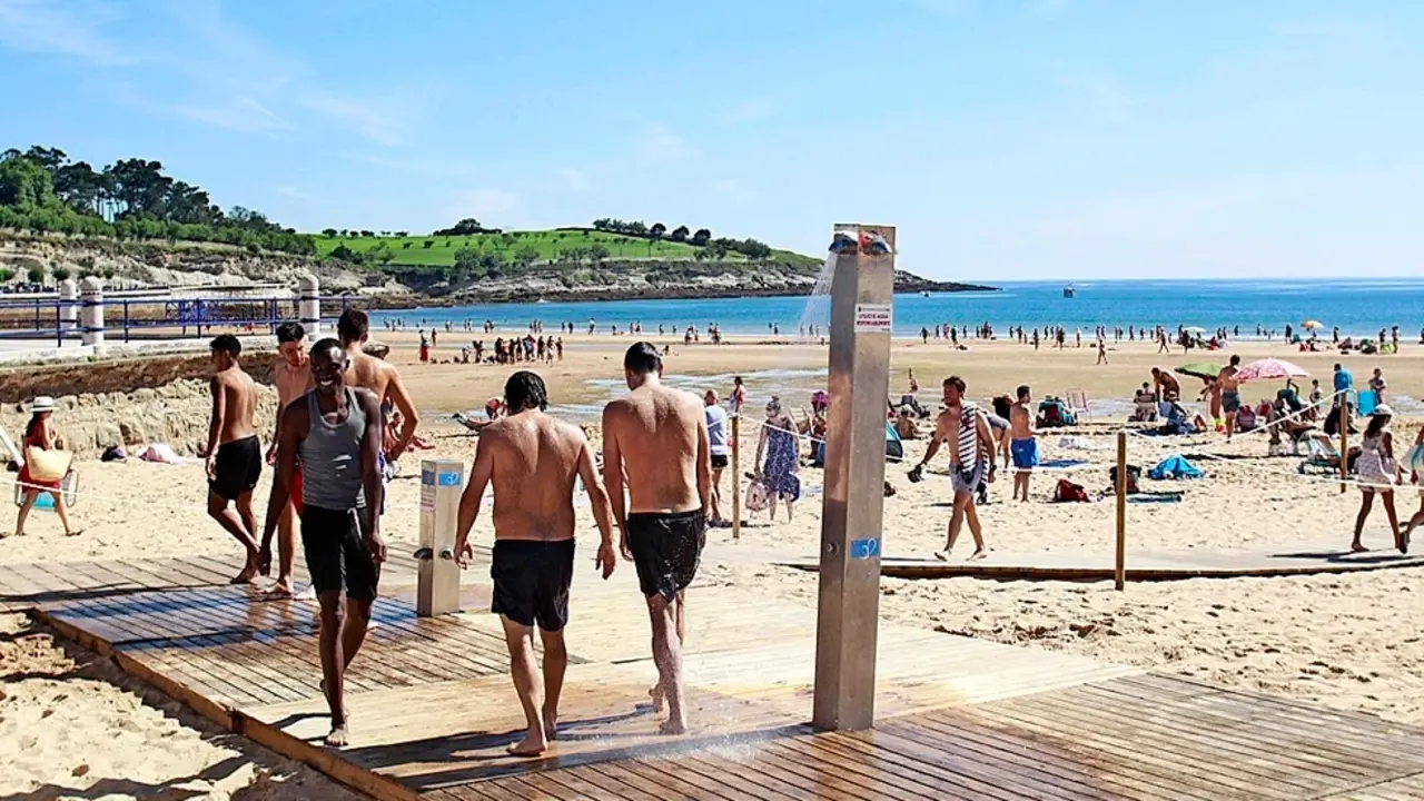 Varias personas disfrutan en la segunda playa del Sardinero en Santander.