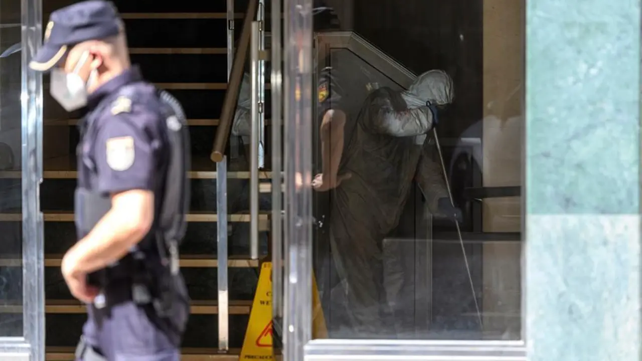 Un hombre desinfecta este martes el portal del edificio de Santander en la calle Nicol&aacute;s Salmer&oacute;n. EFE/Pedro Puente Hoyos
