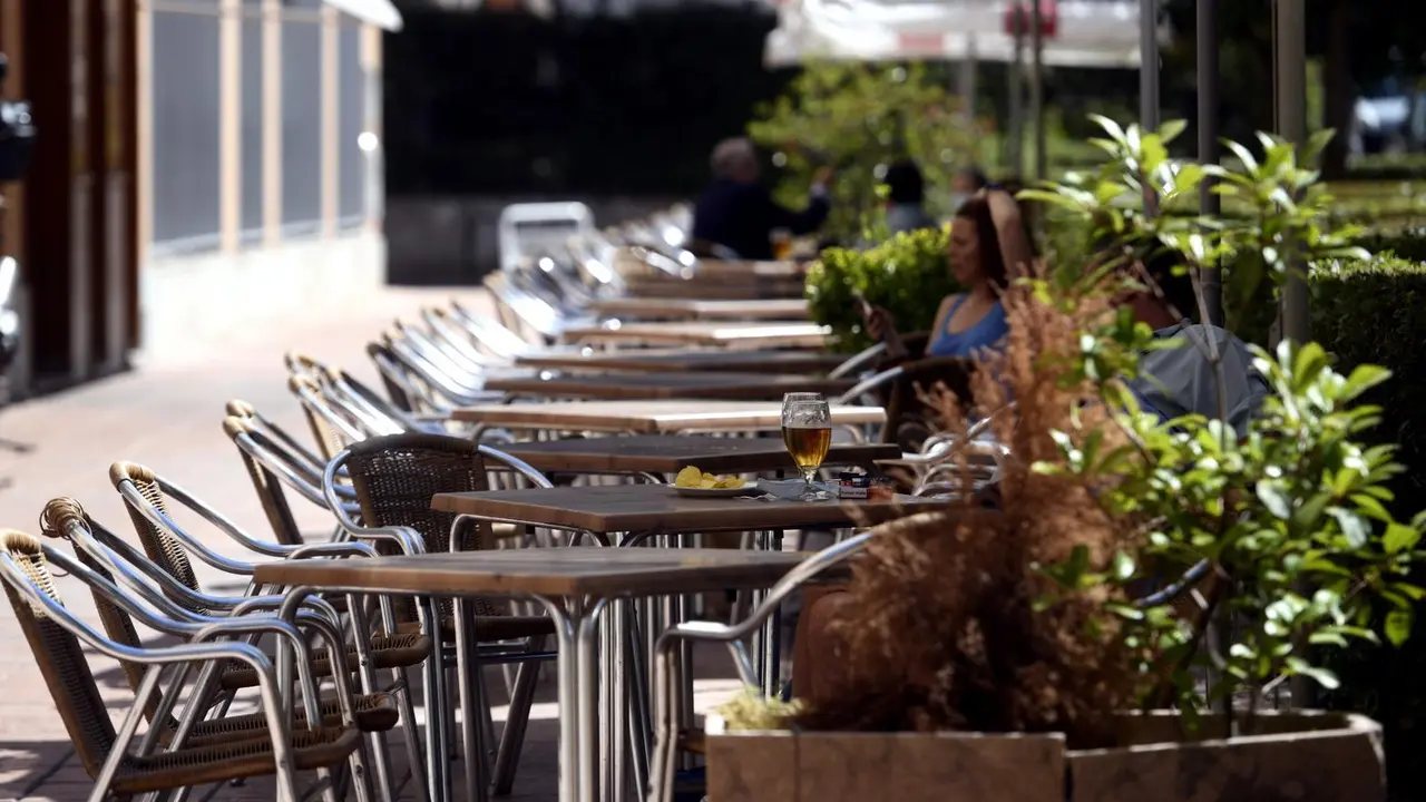 Varias personas disfrutan en una terraza. Archivo
