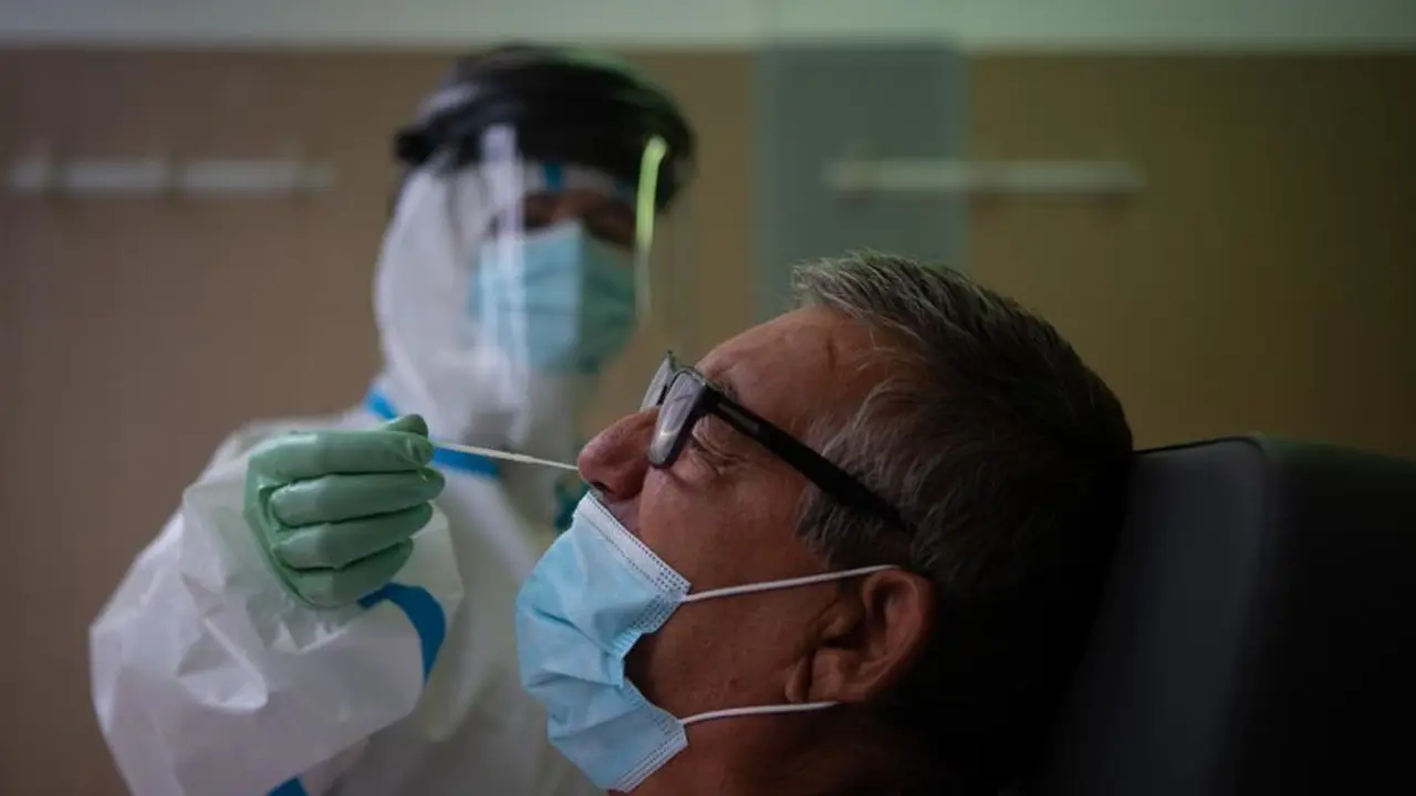 Una profesional sanitaria realiza una prueba PCR a un paciente en el CAP Raval Nord de Barcelona, este viernes. / EFE / Enric Fontcuberta