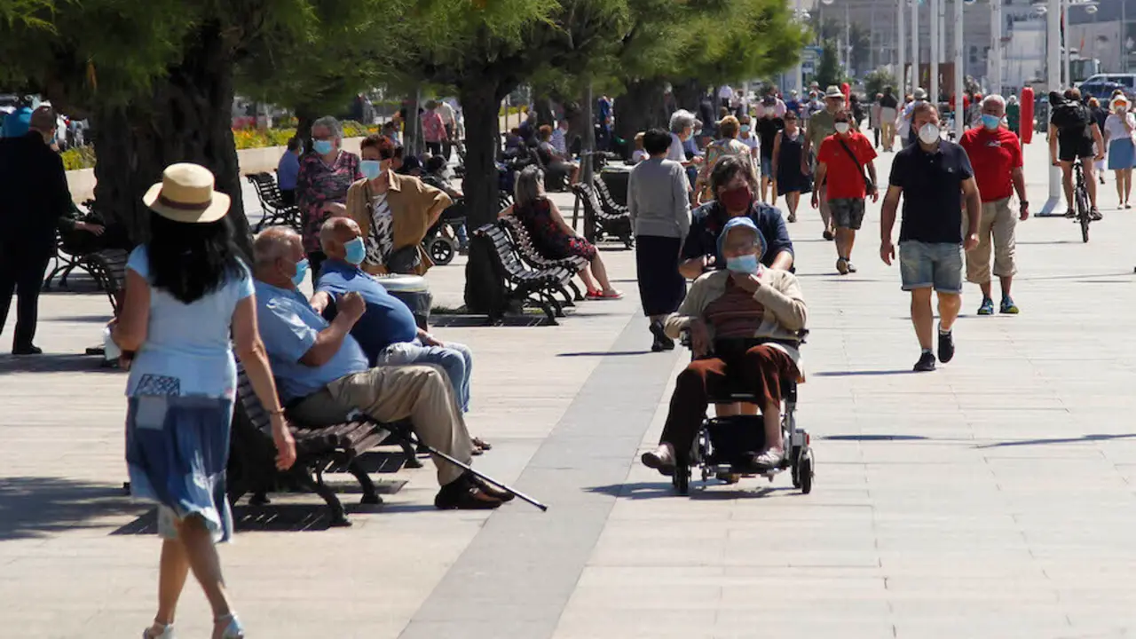 Varias personas disfrutan en el Paseo Mar&iacute;timo de Santander. / J. R.