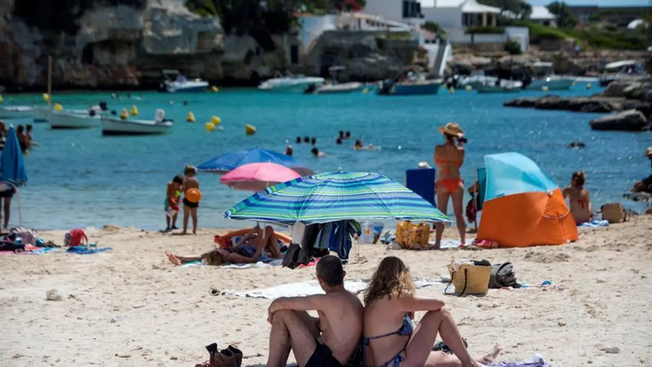 Varias personas disfrutan del sol y del agua en la cala de Alcalfar, Menorca, donde desde el mediod&iacute;a se ha activado la alerta amarilla por calor.EFE/ David Arquimbau Sintes