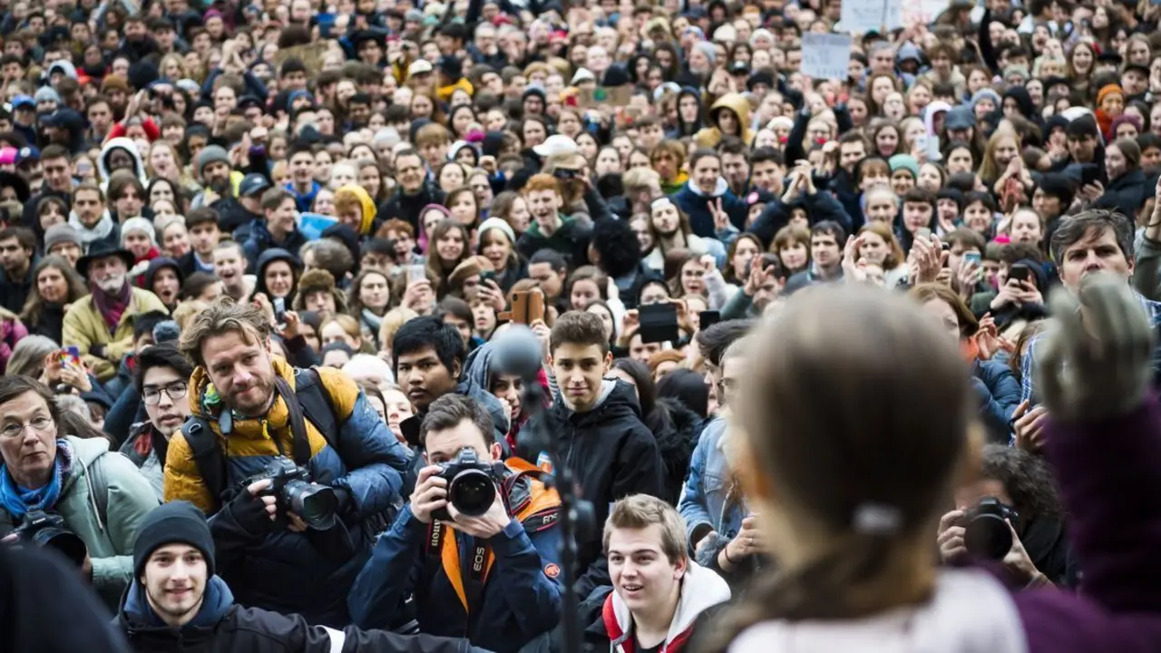 Greta Thunberg saluda a miles de seguidores durante una marcha de acci&oacute;n clim&aacute;tica para demandar soluciones a la emergencia global. EFE/ Jean-christophe Bott/ Archivo