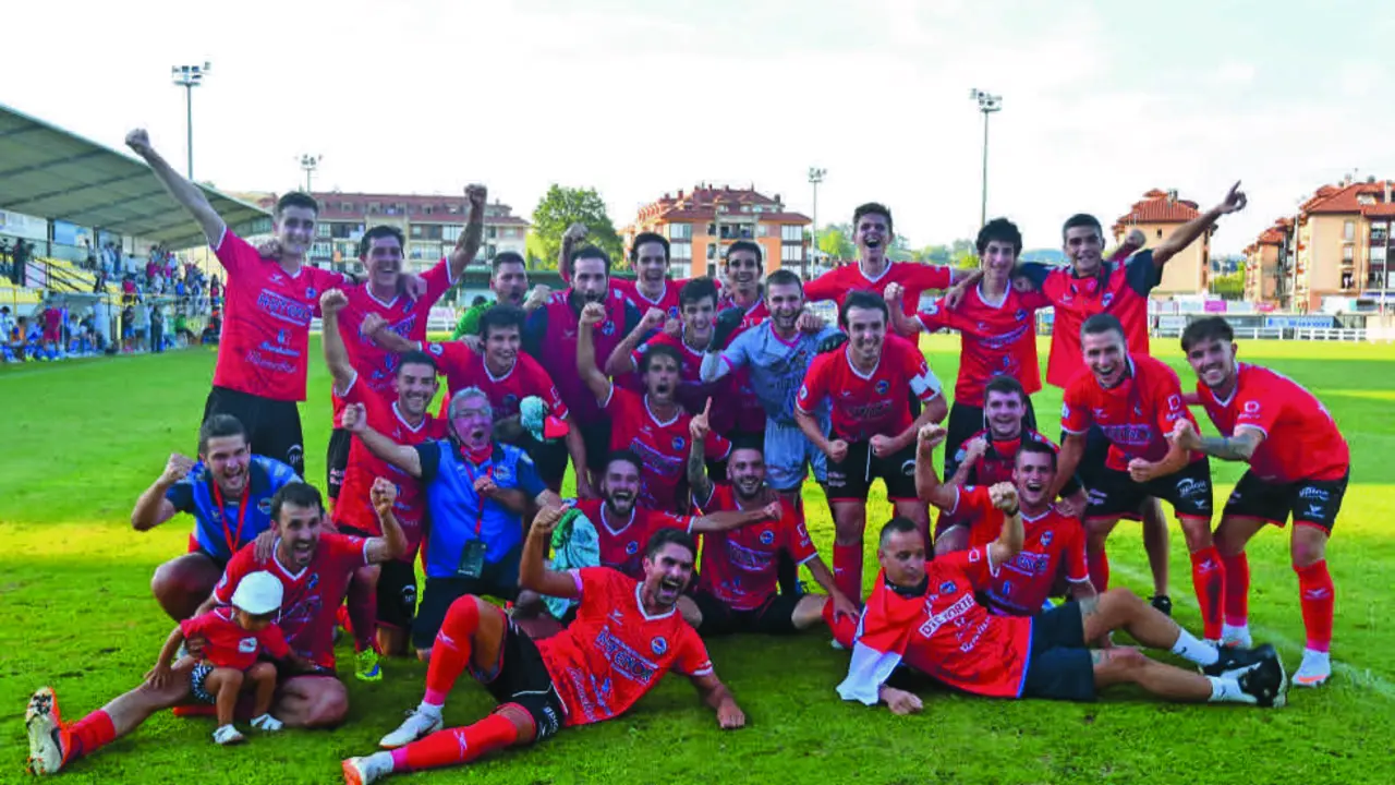 La plantilla del Club Deportivo Laredo celebra el ascenso sobre el c&eacute;sped del Fernando Astobiza de Sar&oacute;n. / Hardy