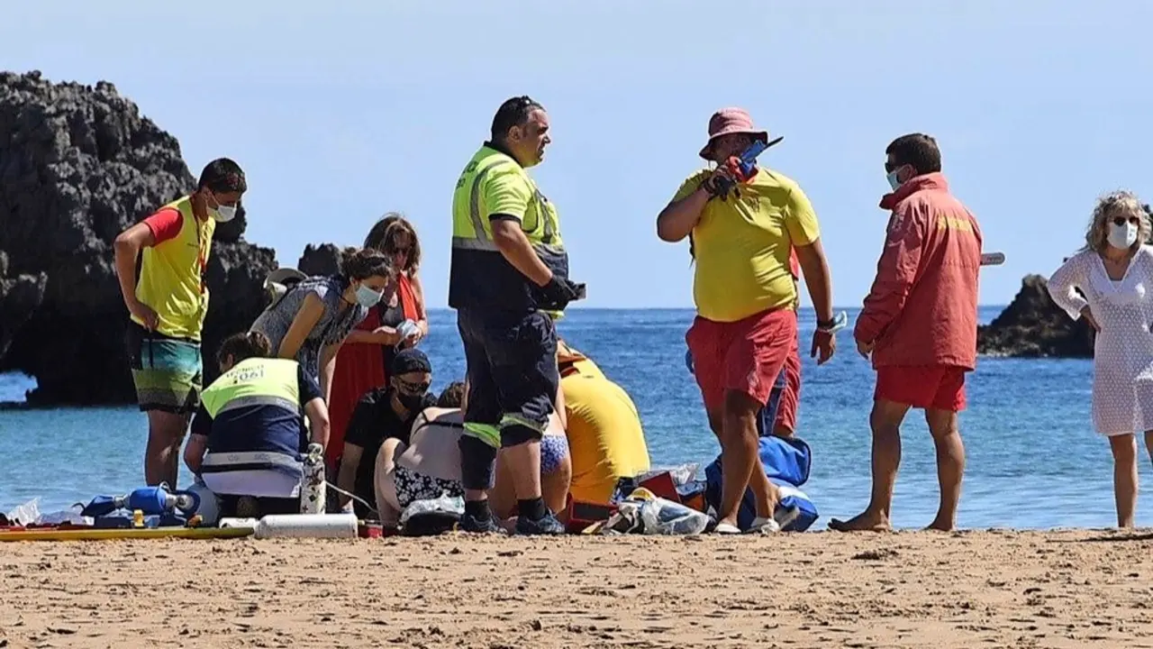 Realizando los ejercicios de reanimaci&oacute;n a la mujer de 85 a&ntilde;os en la playa de Ris en Noja. / ALERTA