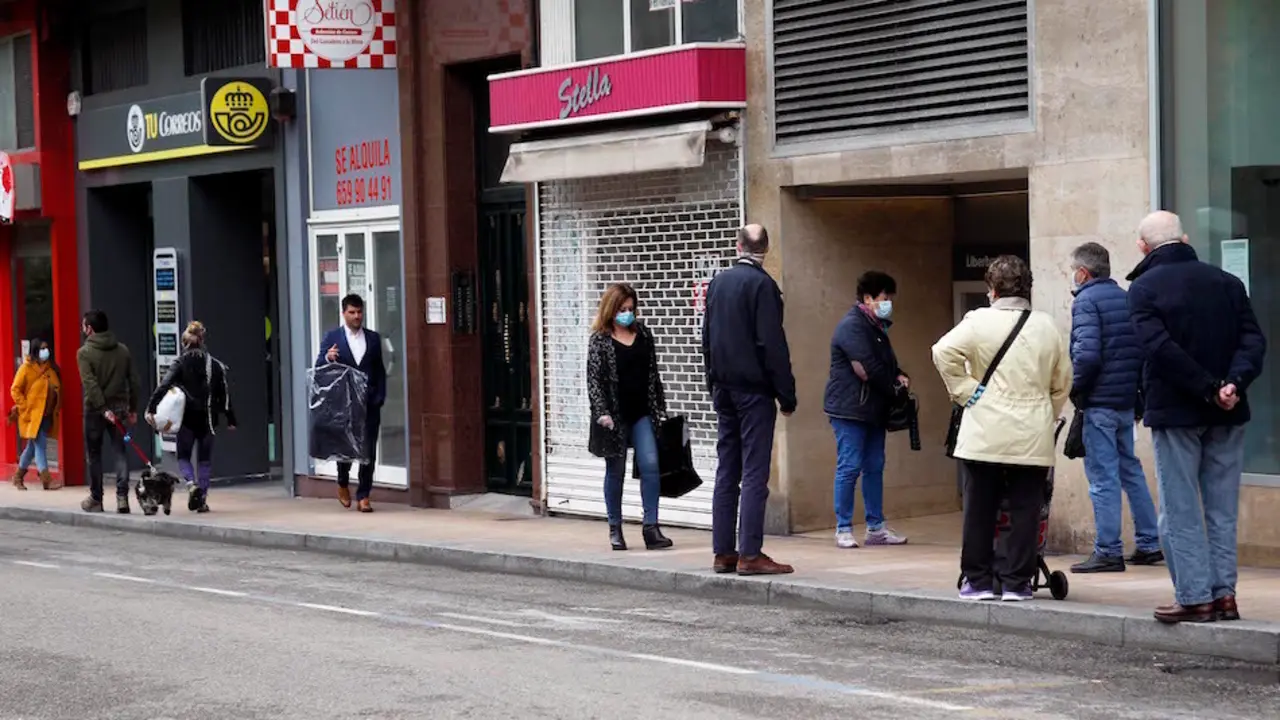 Varias personas junto a comercios cerrados en la calle Vargas, Santander. / J.R.