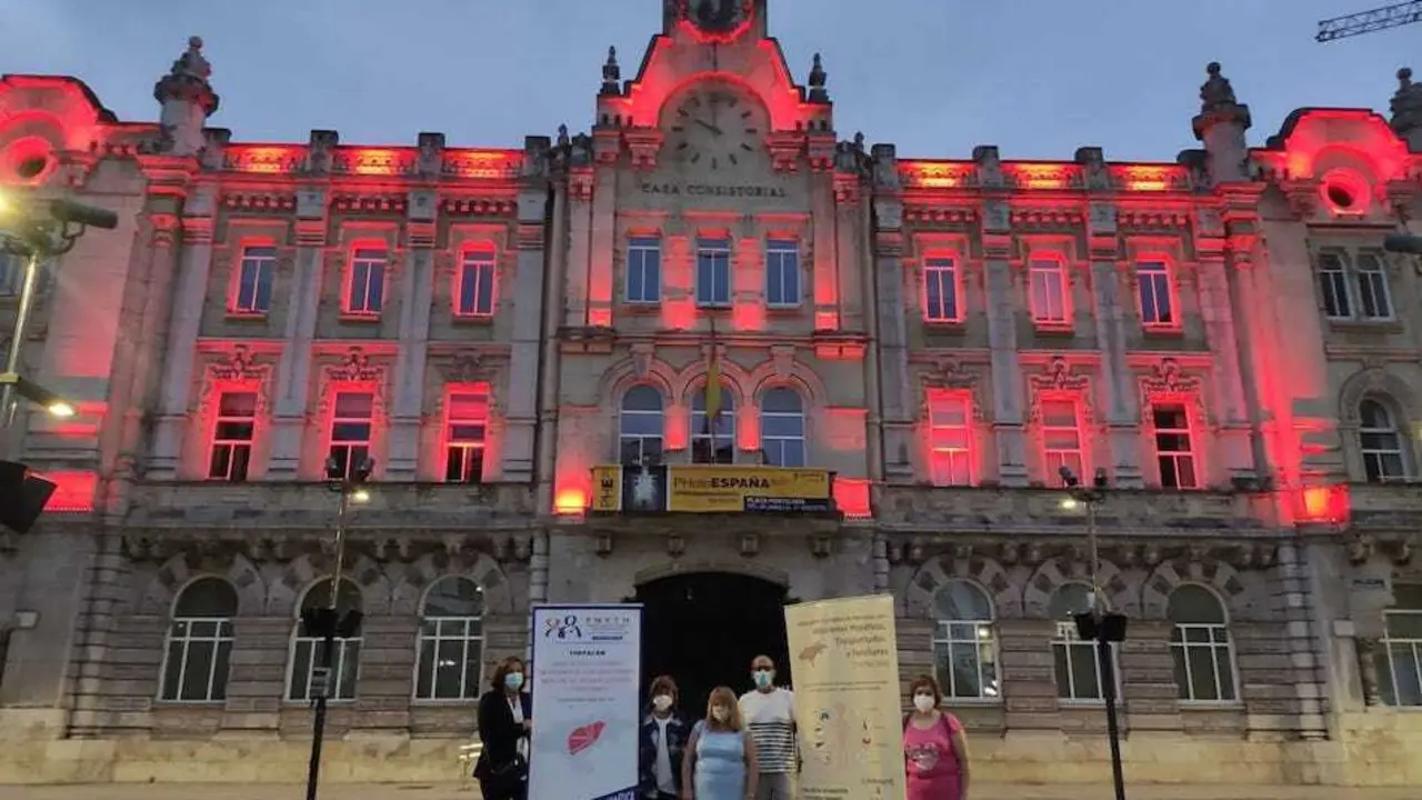 Fachada del Ayuntamiento de Santander iluminada de rojo ayer.
