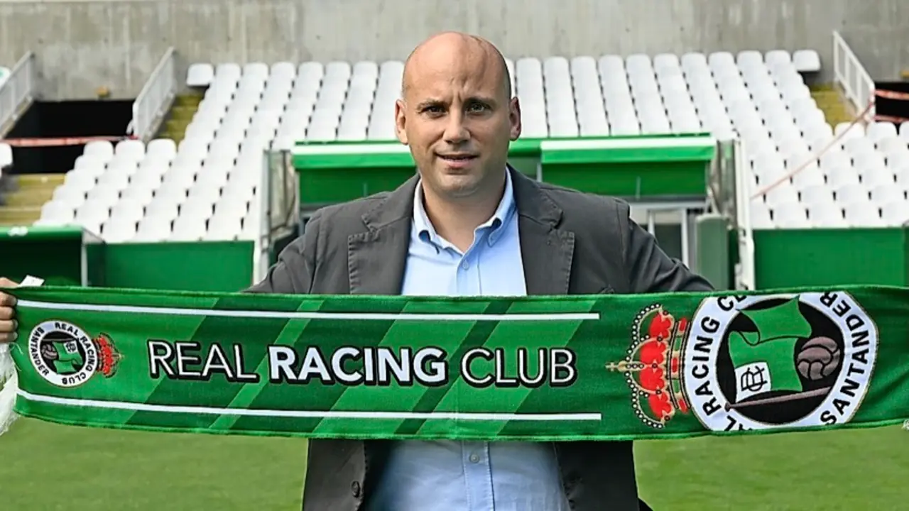 Javier Rozada posa con la bandera del Racing en Los Campos de Sport durante su primer acto p&uacute;blico como entrenador del equipo verdiblanco. / hardy