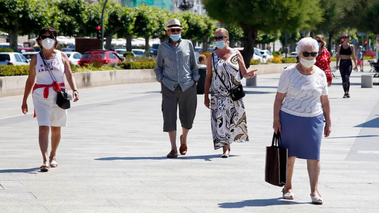 Varias personas con mascarilla pasean junto al embarcadero de La Regina en Santander. / J.R.
