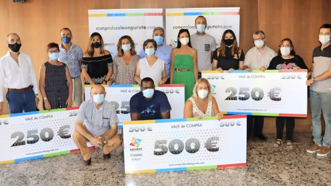 Galardonados y autoridades posan para la foto de familia tras la entrega de los vales de compra. / ALERTA