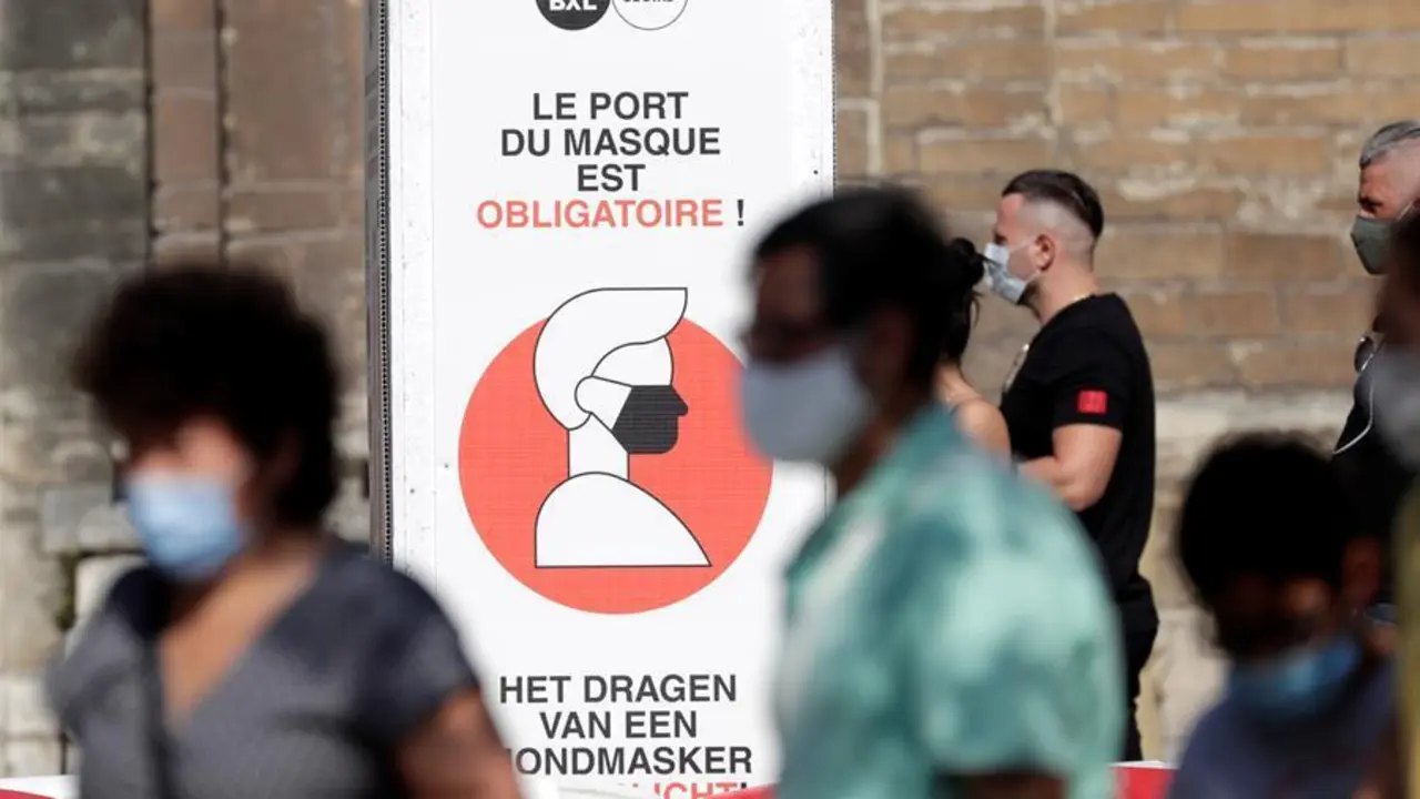 La gente camina junto a un letrero que informa que debe usar m&aacute;scaras faciales en Bruselas, B&eacute;lgica, 12 de agosto de 2020.EFE / EPA / OLIVIER HOSLET