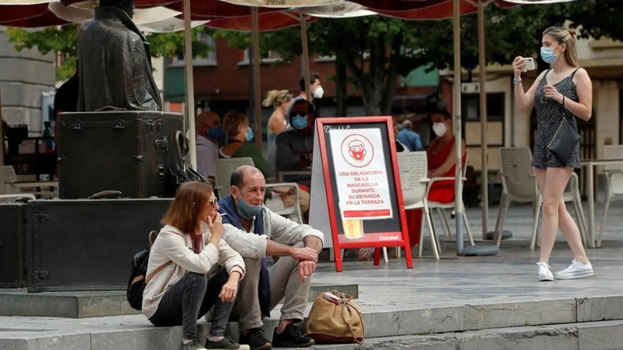 Una pareja de turistas fuman sentados en una plaza del centro de Oviedo. EFE/Alberto Morante
