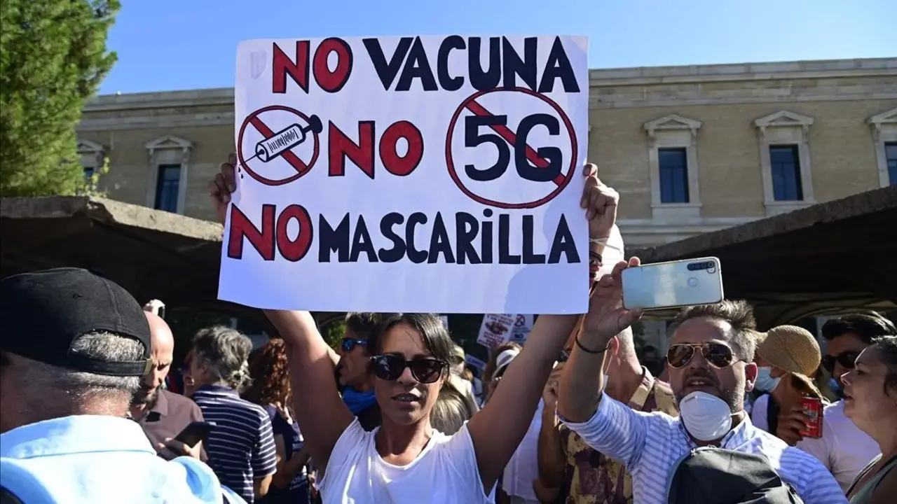 Una manifestante sostiene una pancarta contra la vacuna, contra las mascarillas y contra el 5G durante la protesta de este domingo en Madrid. / JAVIER SORIANO (AFP)
