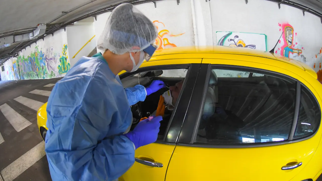 Un t&eacute;cnico sanitario realiza el test PCR en el parking en Santander. / HARDY
