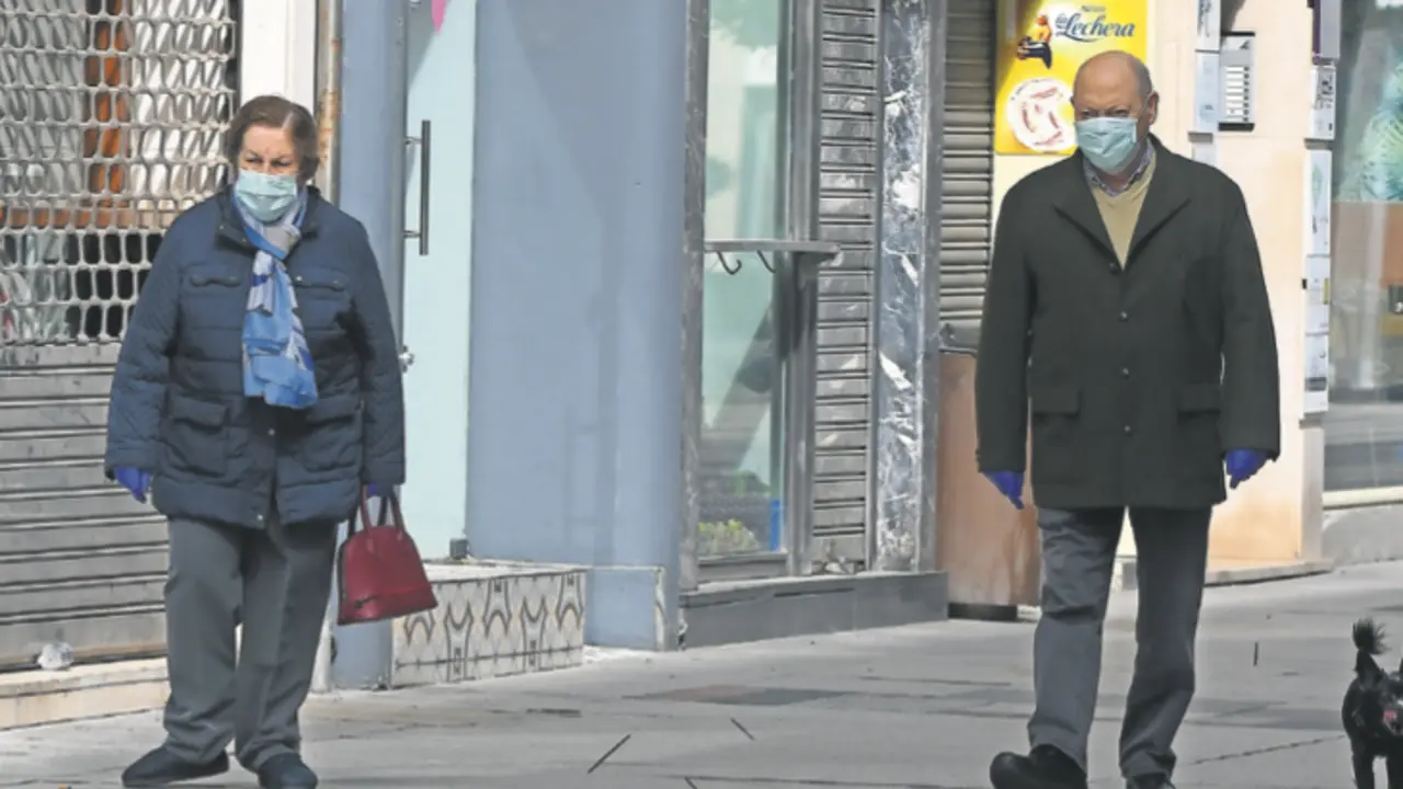 Dos personas de avanzada edad caminan por la calle en Santander con su mascarilla. / CUBERO ARCHIVO