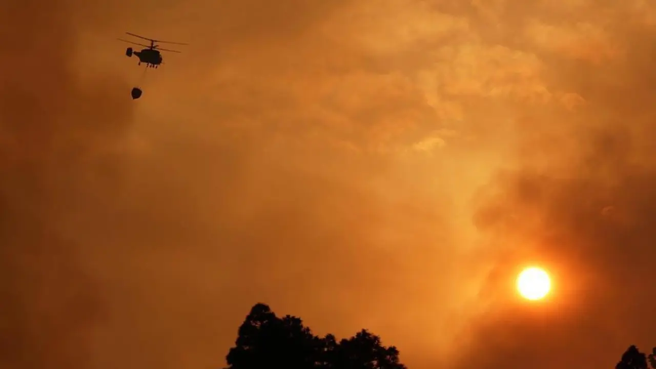 Un helic&oacute;ptero colabora en los trabajos extinci&oacute;n del incendio declarado en el municipio palmero de Garaf&iacute;a este s&aacute;bado. Vecinos de los barrios de Cueva del Agua y El Castillo, en Garaf&iacute;a (La Palma) han sido evacuados de manera preventiva por el incendio forestal que afecta desde ayer al municipio, y que sigue activo con tres frentes. EFE/MIGUEL CALERO
