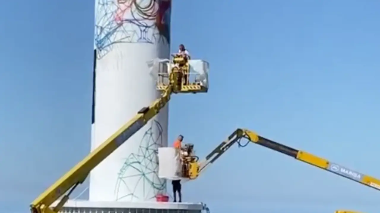 El artista Okuda y sus colaboradores realizando la obra en el Faro de Ajo.