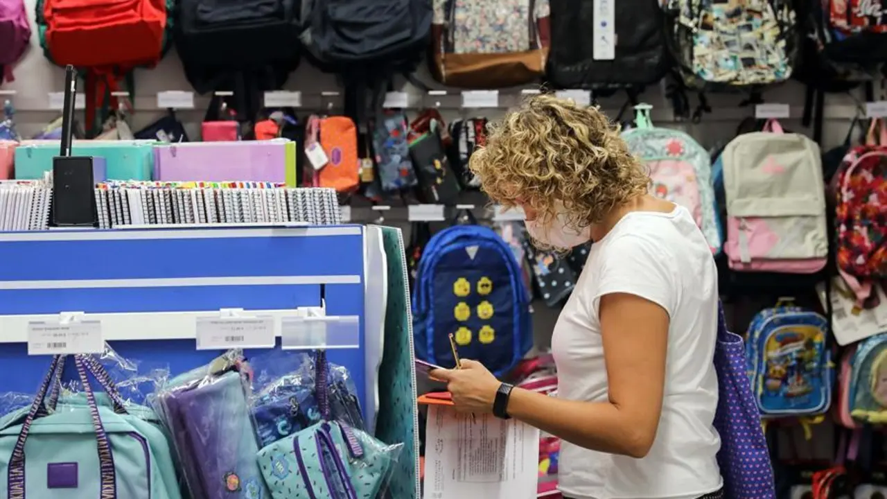 Una mujer, preparada con una lista de material escolar. / Ana Escobar