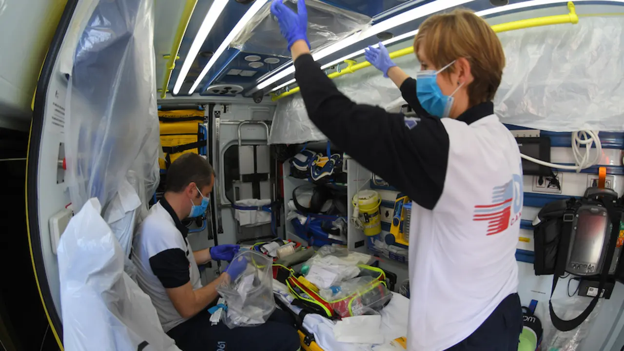 Unos t&eacute;cnicos sanitarios en la ambulancia prepar&aacute;ndola para el traslado de un paciente. / HARDY