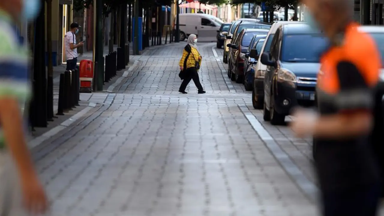 Varias personas caminan por una calle del barrio de La Inmobiliaria en la ciudad c&aacute;ntabra de Torrelavega, a ra&iacute;z del brote detectado tras dos fiestas en las que se habr&iacute;an reunido un centenar de personas. EFE/Pedro Puente Hoyos