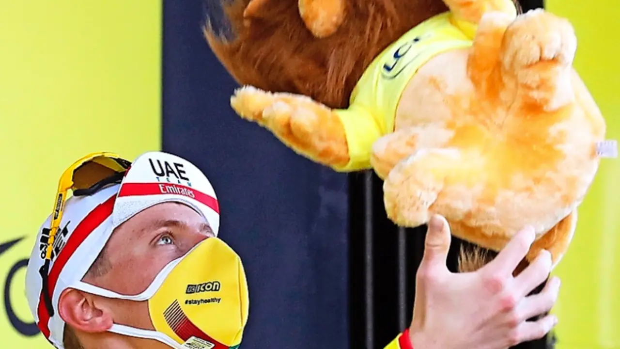 Tadej Pogacar lanza al aire la mascota del Tour tras enfundarse el maillot amarillo. / EFE