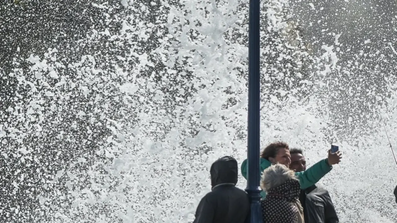 Varios j&oacute;venes se fotograf&iacute;an cerca de la costa tras romper una ola. / HARDY