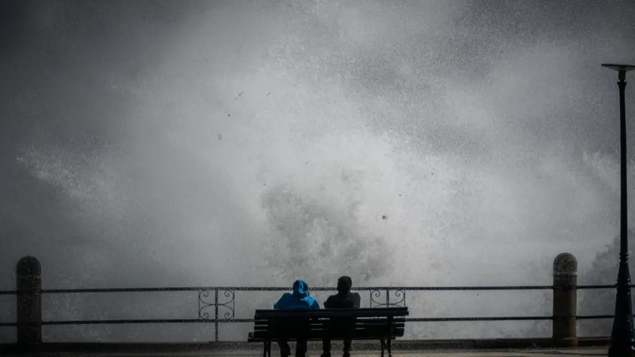 Dos personas contemplan el fuerte oleaje desde un banco en El Camello, durante el temporal que azot&oacute; Santander.
Foto: Nacho Cubero