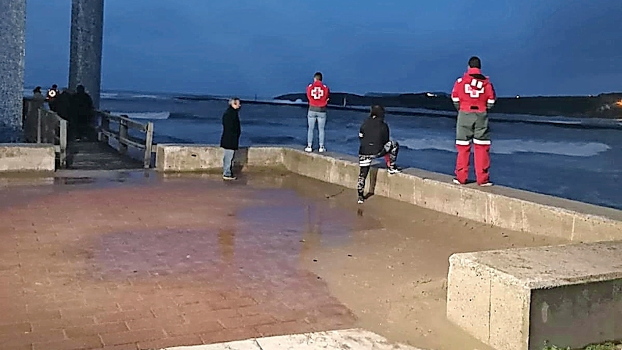 Varias personas observan el agua durante las labores de b&uacute;squeda del hombre que, seg&uacute;n un testigo presencial, cay&oacute; al mar en Suances. / g. cantabria