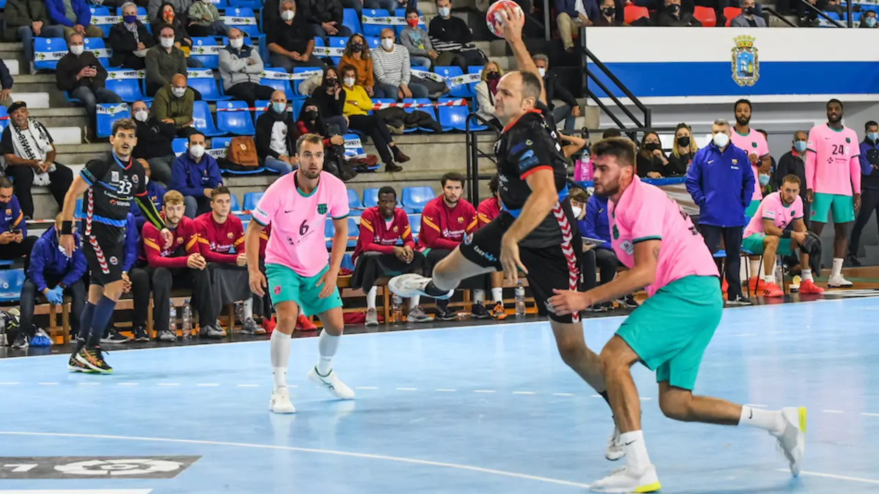 El jugador del Balonmano Sinfin lanza ante un oponente del Bar&ccedil;a. / HARDY