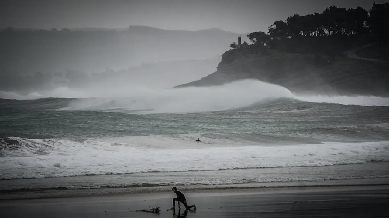 Un surfista en el Sardinero se prepara para hacer deporte en un d&iacute;a en que el temporal &Aacute;lex ha dejado fuertes vientos e importantes lluvias. / HARDY