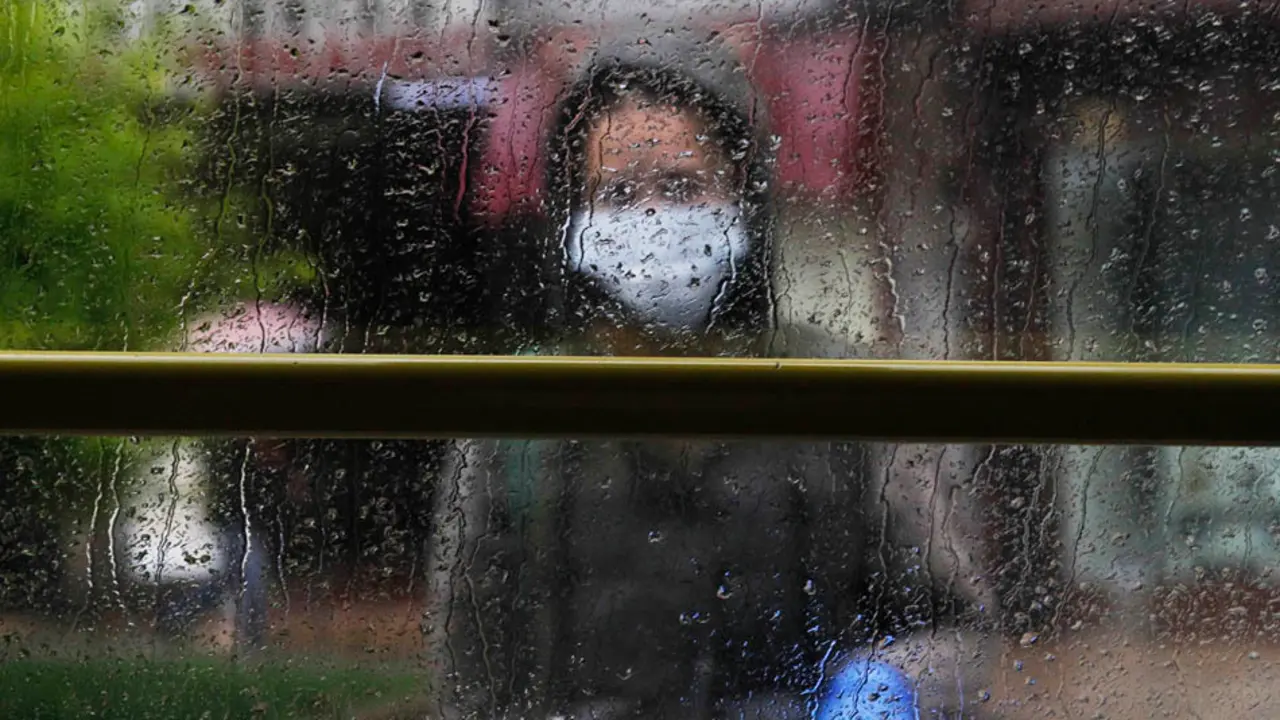 Una persona con mascarilla y guantes espera al autob&uacute;s en una parada en Santander. / J.R.