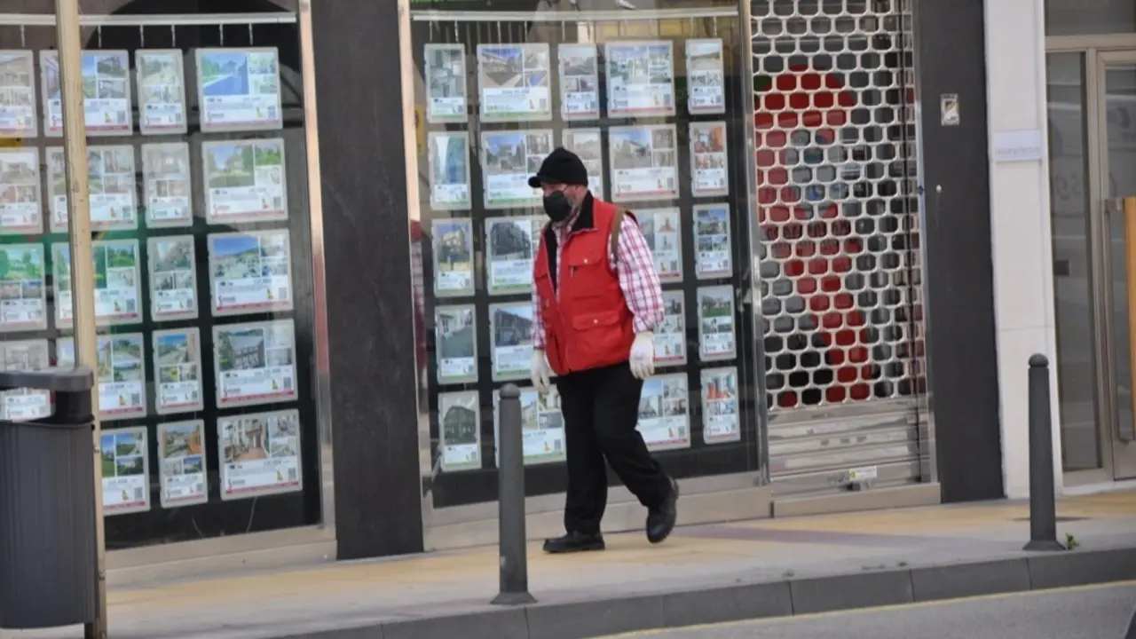 Una persona pasa por delante de un comercio en Torrelavega. / S.D.