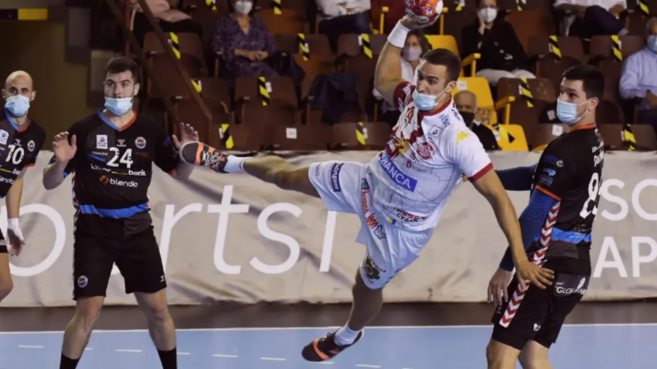 El jugador del Abanca Ademar Drew Donlin (c) lanza ante los jugadore del Sinf&iacute;n Liberbank durante el partido de la octava jornada de la Liga Sacyr ASOBAL disputado hoy en el palacio municipal de deportes de Le&oacute;n. Los jugadores de ambos equipos tuvieron que disputar el encuentro provistos de mascarilla debido a las medidas sanitarias impuestas por la Junta de Castilla y Le&oacute;n para frena la expansi&oacute;n de la pandemia de la cpvid-19. EFE/ J.casares/Foto: J.Casares/EFE