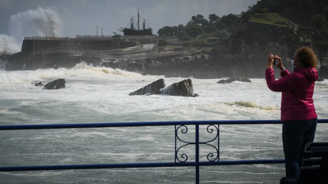 Una mujer hace una foto en paseo de la playa del Camello en Santander la pasada semana cuando azot&oacute; el temporal &Aacute;lex. / Hardy / ALERTA