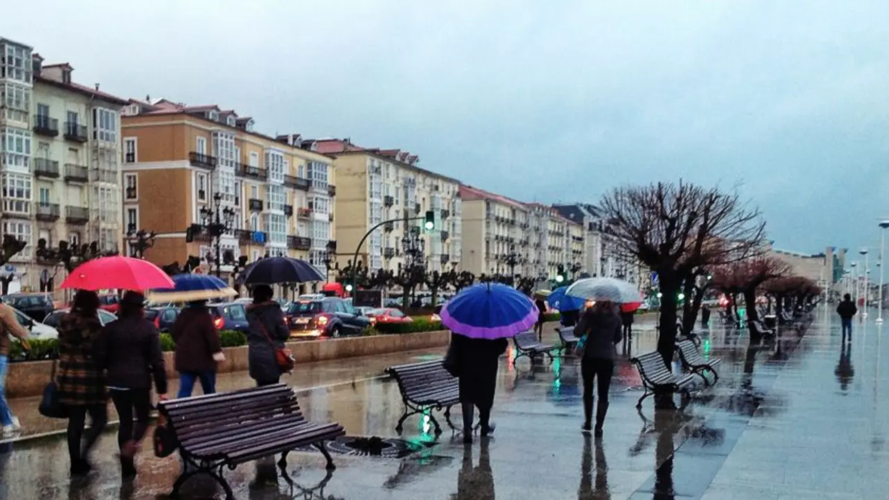 Varias personas caminan por el Paseo Pereda de Santander con sus paraguas. / eltomavistasdesantander