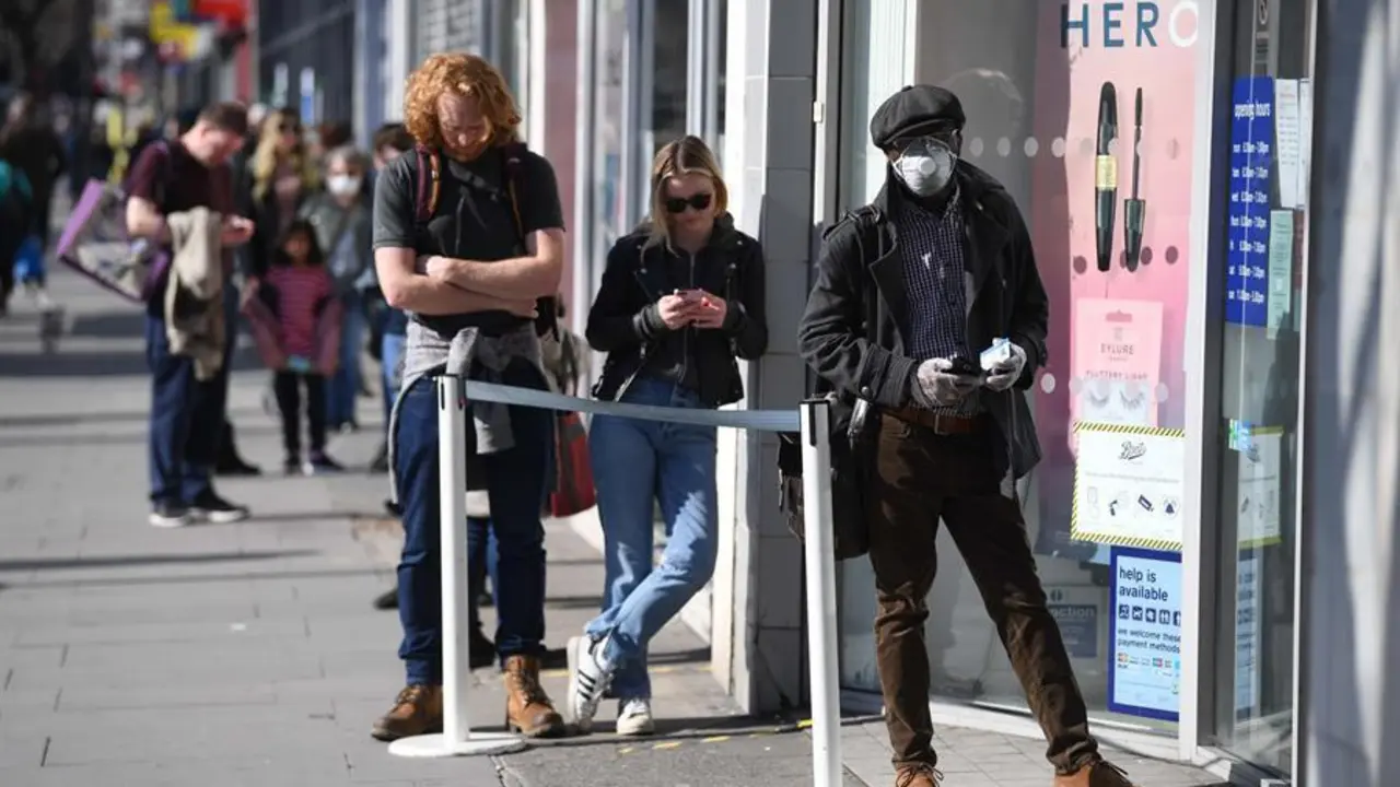 La gente mantiene medidas de distanciamiento social mientras hacen cola para una tienda en Londres, Gran Breta&ntilde;a. EFE/EPA/NEIL HALL/Archivo