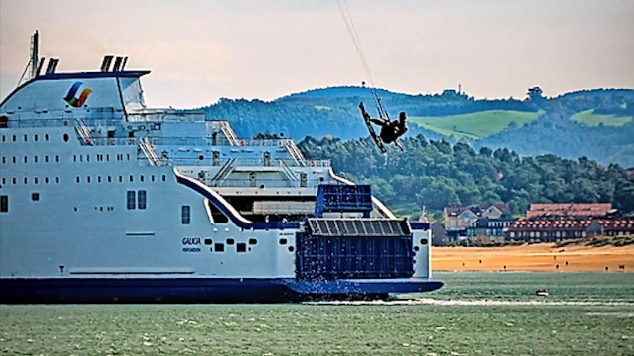 Un 'kitesurfer' practica al paso de un ferry en la bah&iacute;a de Santander, este lunes. EFE/ROM&Aacute;N G. AGUILERA