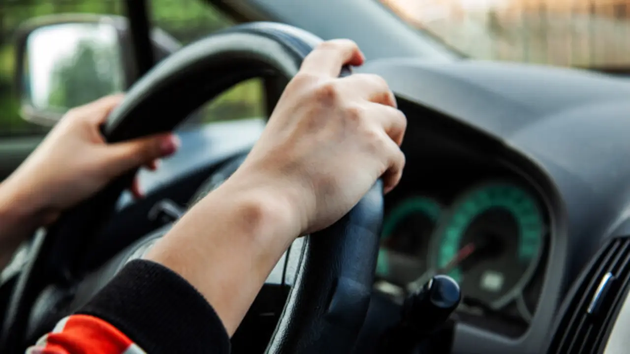 chica-conduciendo-coche-manos-chica-volante_94120-6