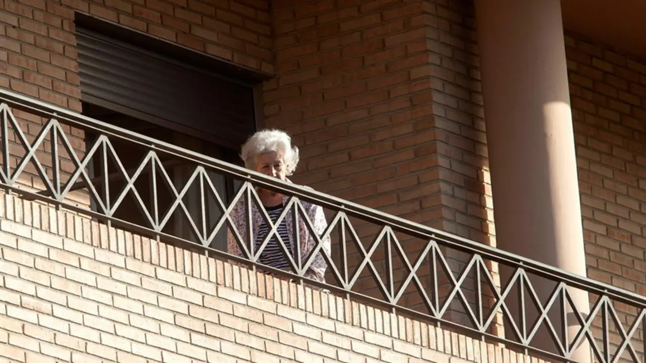 Una mujer este lunes en el balc&oacute;n de su habitaci&oacute;n de la residencia de mayores Ballesol, situada en la urbanizaci&oacute;n Altorreal de Molina de Segura (Murcia),que ha sido intervenida por el Servicio Murciano de Salud (SMS) al detectarse un brote con 79 casos positivos (69 residentes y 10 trabajadores) y el fallecimiento de uno de los afectados. EFE/ Marcial Guill&eacute;n