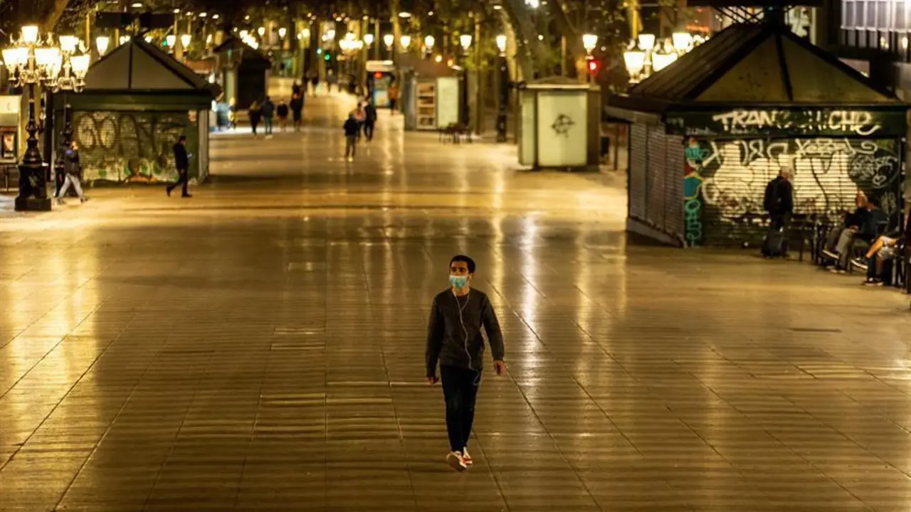 Un hombre pasea hoy domingo por las Ramblas pasadas las 22h, hora decretada por el Gobierno de la Generalitat como inicio del confinamiento nocturno hasta las 6h. El Gobierno de Espa&ntilde;a ha decretado el estado de alarma desde las 11pm. a las 6 am. para todo el territorio nacional, con posibilidad de peque&ntilde;as modificaciones aplicadas por los gobiernos auton&oacute;micos. EFE/Enric Fontcuberta