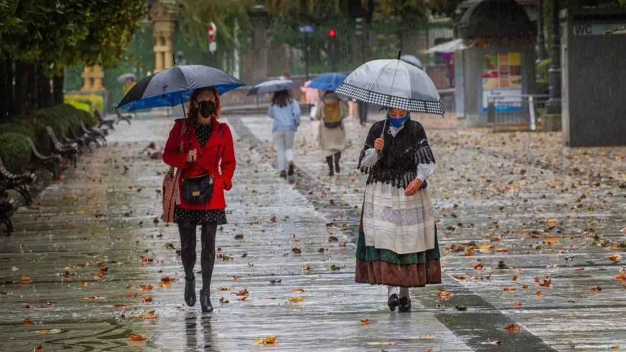 Dos mujeres pasen bajo la lluvia en el paseo de Los &Aacute;lamos, en el centro de Oviedo. Asturias y ocho comunidades mas, est&aacute;n hoy en alerta meteorol&oacute;gica, por viento y intensa lluvia, que podr&iacute;a dejar hasta 40 litros por metro cuadrado en 12 horas, y fuertes olas en el litoral. EFE/ Alberto Morante