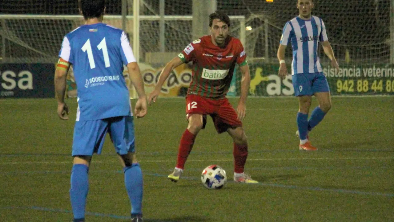 El jugador de la Gimn&aacute;stica retiene el bal&oacute;n ante los jugadores del Barreda.