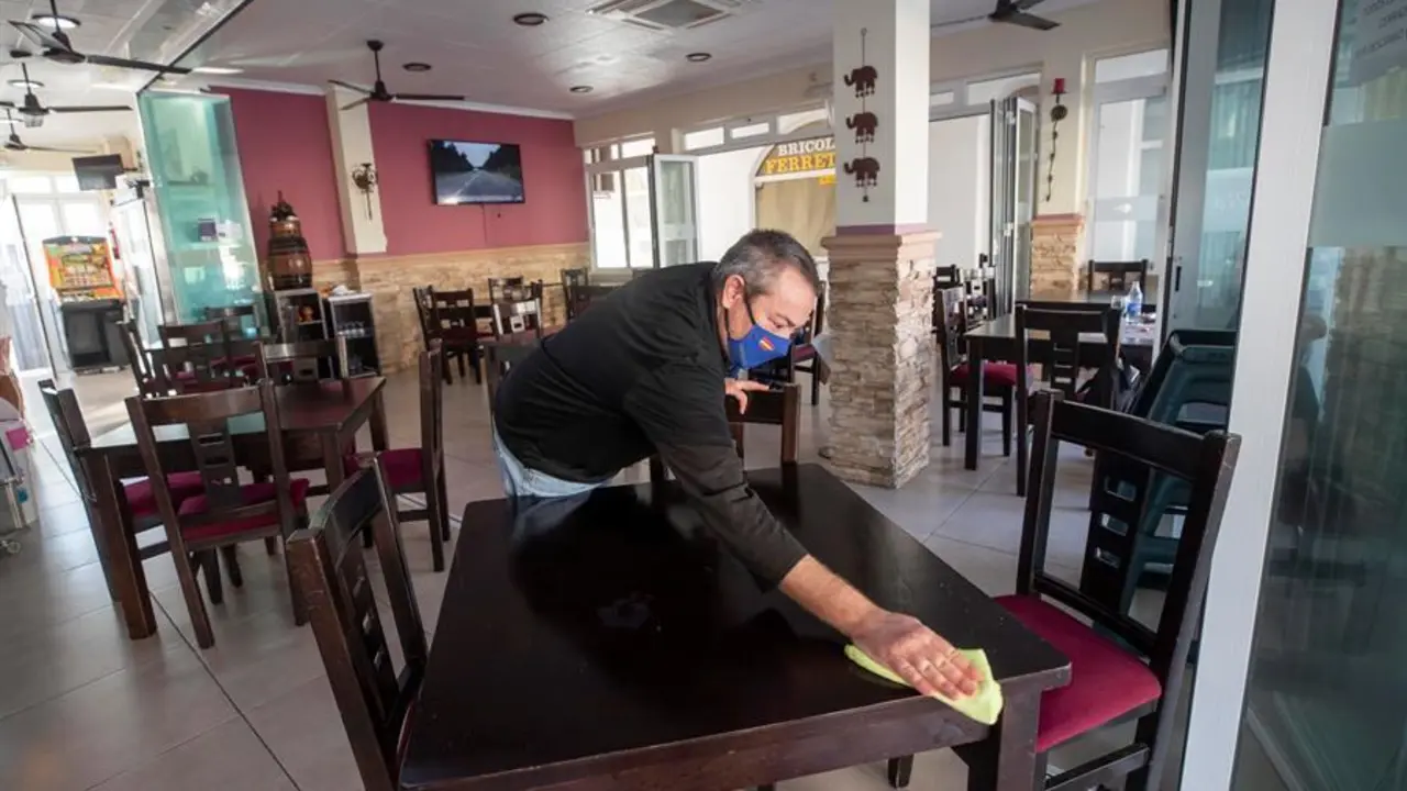 Un camarero limpia una mesa de un restaurante vac&iacute;o en La Manga del Mar Menor. / EFE
