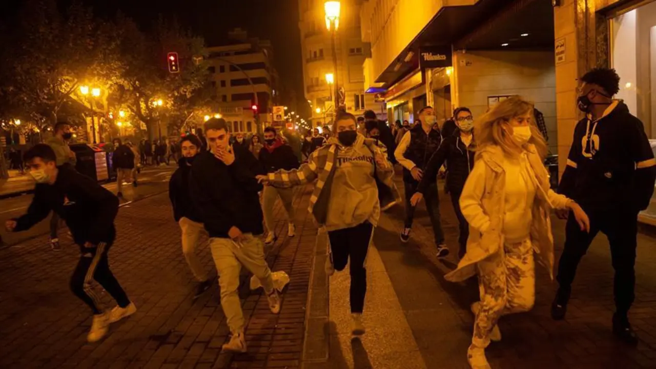 Unos 150 radicales, muchos de ellos j&oacute;venes, han protagonizado esta tarde-noche disturbios en el centro de Logro&ntilde;o, donde han cruzado y quemado contenedores, han tirado piedras y botellas de crisital a la Polic&iacute;a y han cortado el tr&aacute;fico en las cercan&iacute;as del Ejecutivo riojano y de la Delegaci&oacute;n del Gobierno en La Rioja. En la imagen, varias personas se alejan de la zona donde se producen los altercados. EFE/Raquel Manzanares